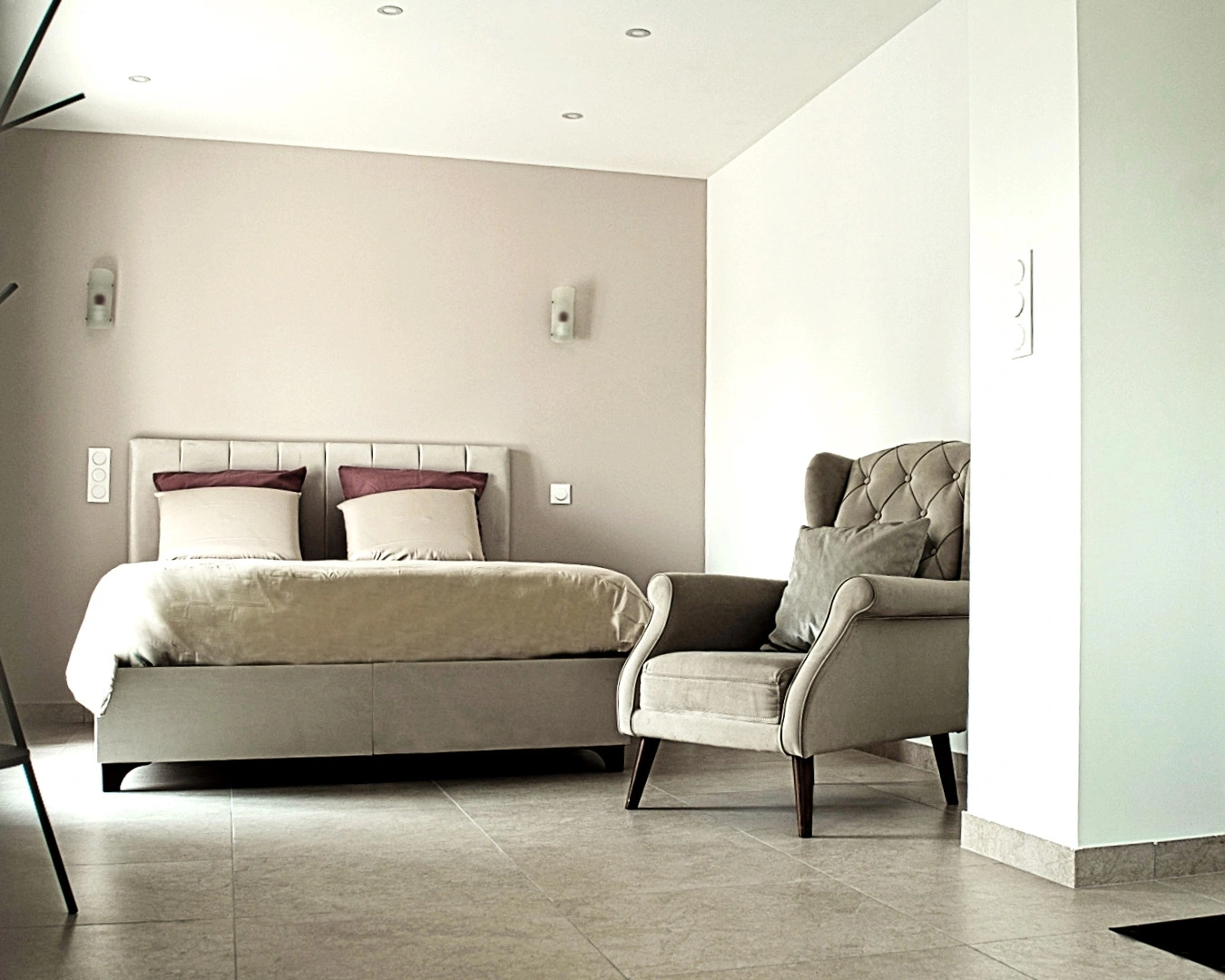 Notre chambre spacieuse et élégamment aménagée vous offre tout le confort pour un séjour relaxant dans un coin calme de la Bourgogne Franche-Comté. Lit double confortable, fauteuil cosy, espace kitchenette avec évier, TV murale, et décoration moderne : un hébergement idéal pour les couples ou voyageurs de passage à Montbéliard, dans le Doubs.