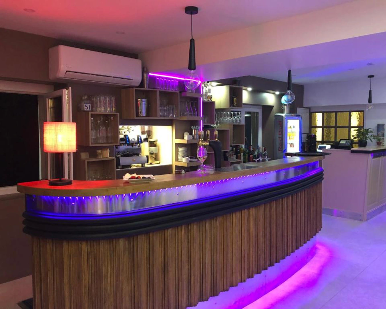 Ambiance lounge au bar de l’hôtel-restaurant Belle'Man près de Montbéliard, dans le Doubs (Bourgogne Franche-Comté) Cette photo met en lumière l’intérieur du bar de l’hôtel-restaurant Belle'Man, situé à proximité de Montbéliard, au cœur du Doubs, en Franche-Comté. Ce lieu chaleureux et moderne, sublimé par des jeux de lumière violette et un mobilier boisé, offre un cadre idéal pour se détendre après une journée de découverte de la région. Le bar propose une sélection de boissons, cocktails et apéritifs dans une atmosphère conviviale, parfaite pour les clients de l’hôtel comme pour les visiteurs du restaurant. C’est un espace clé de cet établissement du nord Franche-Comté, où hospitalité, confort et convivialité se rencontrent.