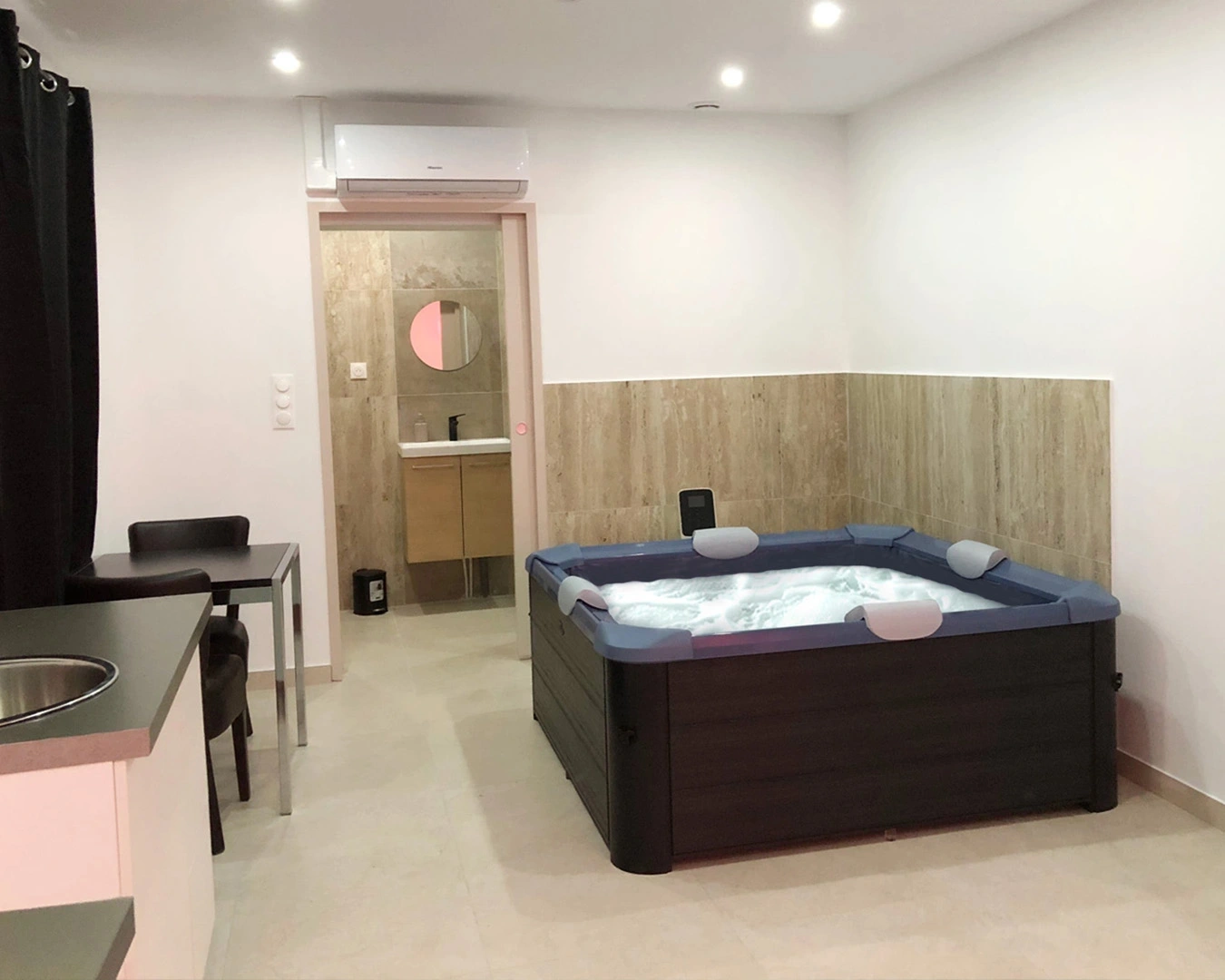 Suite moderne avec jacuzzi privatif, coin repas et salle de bain attenante – hébergement de luxe à Montbéliard en Franche-comté.